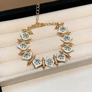 Vintage style gold-plated heart bracelet with white enamel, blue patterns and rhinestones