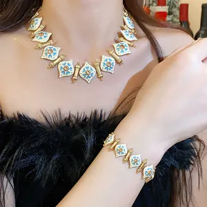 Vintage enamel floral jewelry set featuring a gold-tone necklace and bracelet worn by model