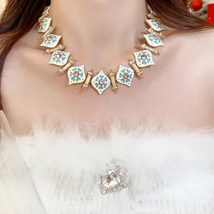 Close-up of a vintage heart necklace with white enamel and rhinestone details