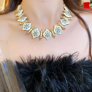 Close-up of a vintage enamel necklace with intricate blue patterns and rhinestones for women.