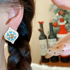 Detailed view of vintage rhinestone heart earring worn by a model in warm light