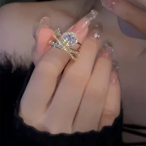 Nahaufnahme eleganter vergoldeter Stapelringe mit funkelndem Zirkon am Finger für Damen