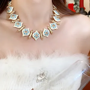 Close-up view of a vintage heart necklace featuring blue enamel and gold-toned finish