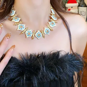 Close-up of vintage-style enamel necklace with light blue floral details on model