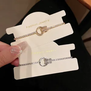 Detaillierte Ansicht von vergoldeten und versilberten Zirkonia-Armbändern auf Karten.