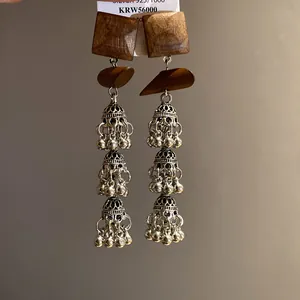 Detail shot of retro ethnic bohemian earrings with wooden squares and silver tassels