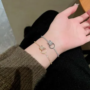 Detailansicht von gold- und versilberten Zirkon-Armbändern an einem Handgelenk eines Models