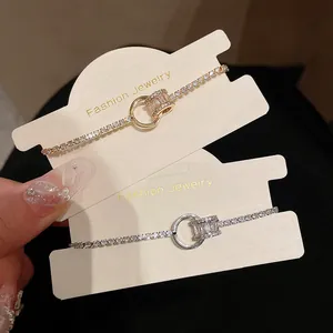 Nahaufnahme von eleganten gold- und silberfarbenen geometrischen Zirkonarmbändern.
