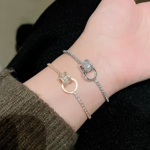Detailansicht von ineinandergreifenden Gold- und Silberarmbändern mit Zirkonia-Zylinder