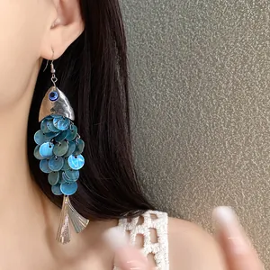 Vue détaillée de boucles d'oreilles vintage en forme de poisson avec des écailles irisées