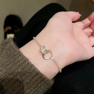 Nahaufnahme eines vergoldeten Armbands mit Zirkonia an einem weiblichen Handgelenk.
