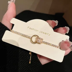 Nahaufnahme eines vergoldeten geometrischen Armbandes mit Zirkonia auf Schmuckkarte