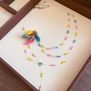 Macro detail of a handmade colorful beaded necklace with a central floral bead element.
