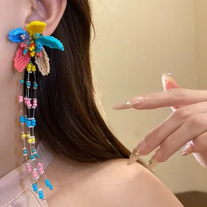 Detailed view of colorful handmade beaded flower drop earrings with elegant long tassel strands