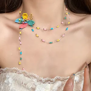 Detailed view of the colorful fabric flower and beadwork on this holiday style necklace.
