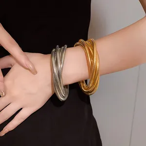 Detail view of stylish gold and silver multi-layer metal spring bracelets on arm