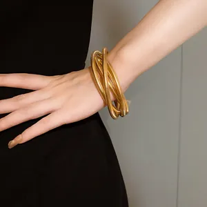 Multi-layer gold spring bracelet detail shown on wrist for a minimalist modern look.