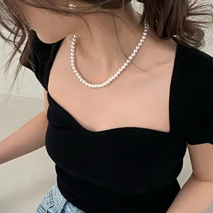 Vue détaillée d'un élégant collier de perles de style français sur un mannequin en noir