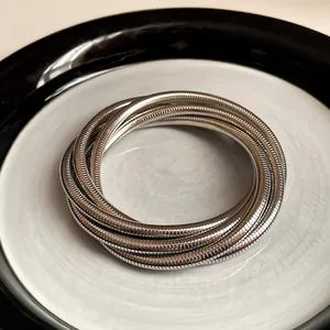 Close-up of a multi-layer silver spring bracelet with minimalist metal texture