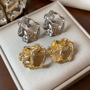 Detail of 18k gold plated crumpled geometric ear clips in gold and silver finish