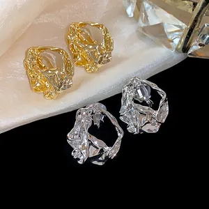 Detail view of 18k gold and silver plated crumpled geometric ear clips