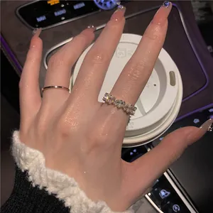 Elegant gold-plated geometric zircon ring set shown on a hand in a luxury car interior