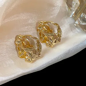 Close-up detail of 18k gold plated geometric clip-on earrings featuring a unique crumpled texture