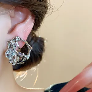 Detail view of 18k gold plated crumpled geometric ear clips for non-pierced ears