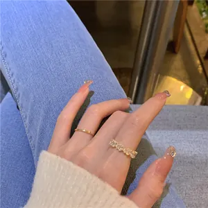 Close-up of gold-plated rings with zircon stones on a hand in a stylish lifestyle setting.
