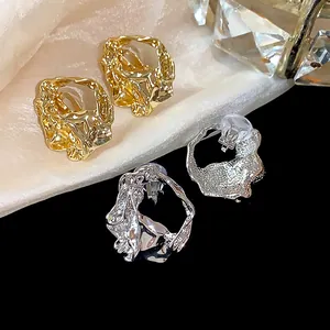 Close-up of 18k gold and silver plated wrinkled geometric ear clips for non-pierced ears.