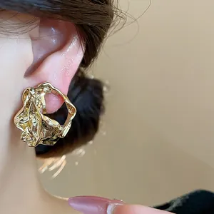 Detailed macro view of 18k gold plated crumpled geometric clip-on earring on ear