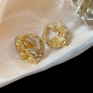 Close-up of irregular textured gold-plated clip-on earrings for non-pierced ears