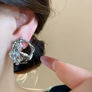 Close-up of silver geometric wrinkled ear clips for non-pierced ears