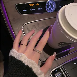 Close-up macro view of luxury geometric zircon ring and gold band set on hand in car