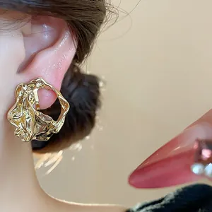 Close-up of minimalist 18k gold-plated crumpled geometric ear cuff for non-pierced ears.