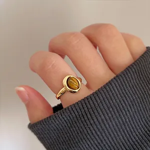 Detailed macro view of a vintage tiger's eye stone open ring worn on a model's finger