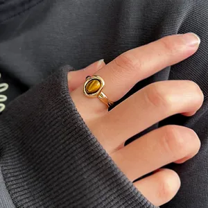 Detailed macro view of an irregular gold ring featuring a polished tiger eye stone.