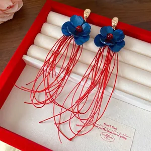 Vintage-Ohrringe aus Acrylblumen mit langen roten Fadentroddeln in einer Schmuckschatulle