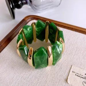 Primo piano di un bracciale retrò in acrilico marmorizzato verde con accenti dorati