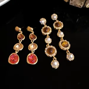 Detailed close-up of French court style dangle earrings with pearls and red crystals.