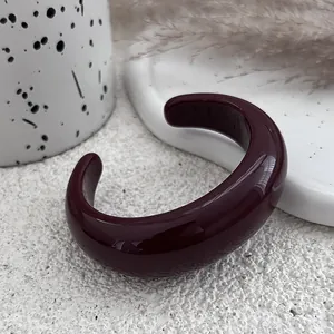 Detailed close-up of a chunky burgundy resin open cuff bracelet with high gloss finish