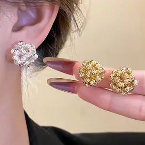 Close-up view of 18k gold plated round flower cluster earrings in gold and silver