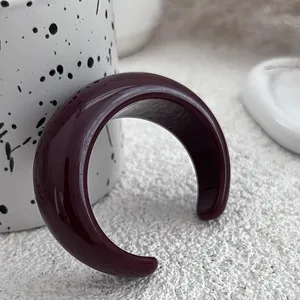 Macro view of burgundy acrylic cuff bracelet with a glossy and minimalist finish