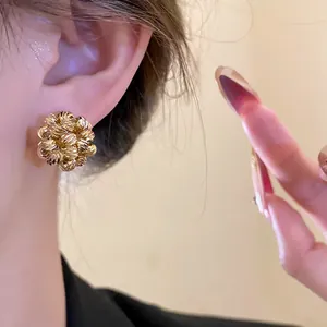 Close-up detail showing the intricate texture of 18k gold plated flower cluster clip-on earrings
