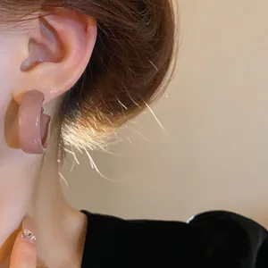 Close-up of pinkish-brown oil-dripping hoop earrings worn by an Asian model