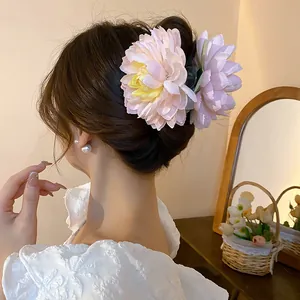 Close-up of a delicate fabric flower hair claw clip on an elegant updo hairstyle