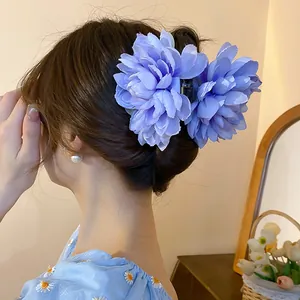 Close-up of a sweet light blue fabric flower hair claw clip elegantly worn in hair