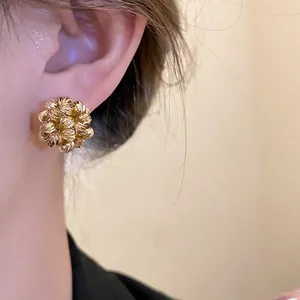 Detailed view of 18k gold plated floral cluster earring showing textured beads on ear.