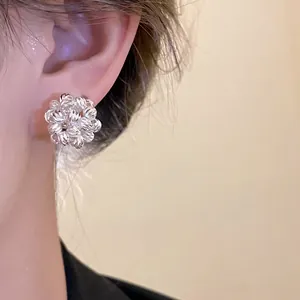 Elegant close-up detail of 18k gold plated flower cluster stud earring worn on ear.