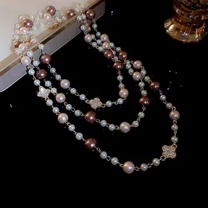 Detailed close-up of a multi-layered pearl necklace featuring rhinestone-encrusted flowers